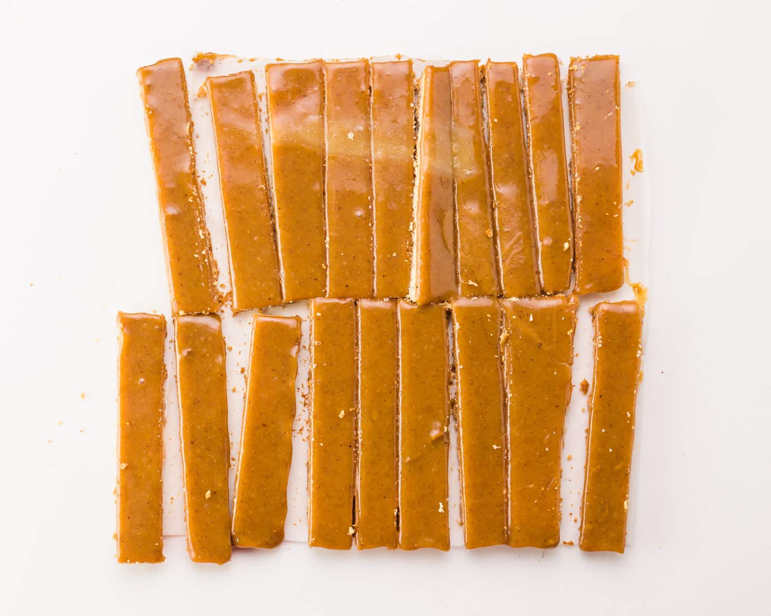 Cookies toped with caramel have been cut into bars.