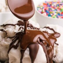A spoon drizzles chocolate topping over ice cream. The text reads, Deliciously Vegan Magic Shell.