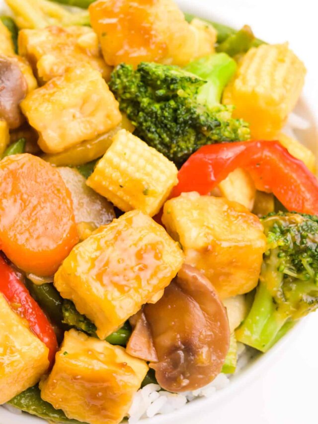 A bowl of teriyaki tofu stir fry features veggies and fried tofu with a thick sauce.