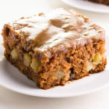 A slice of easy vegan apple cake sits on a plate.