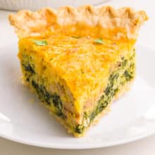 A slice of eggless quiche sits on a plate.