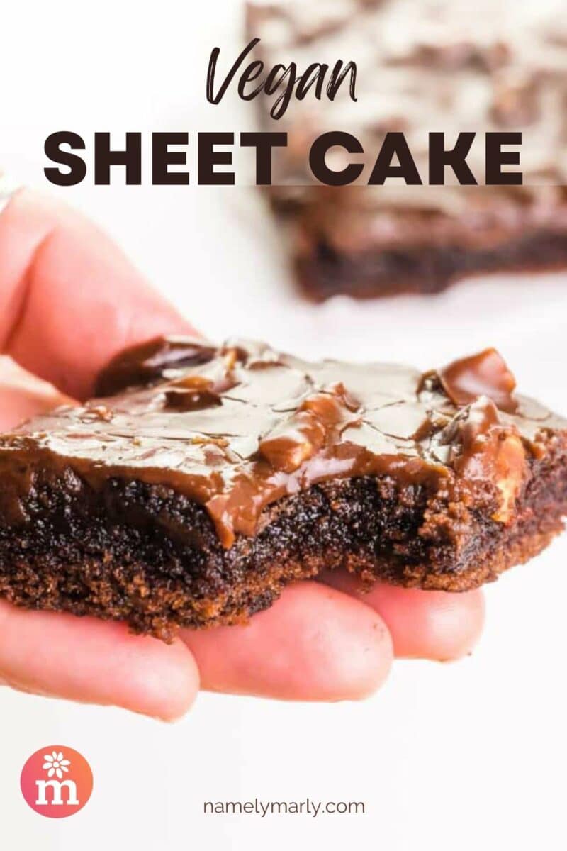 A hand grabs a piece of sheet cake and takes a bite out.  Written in text, vegan sheet cake.