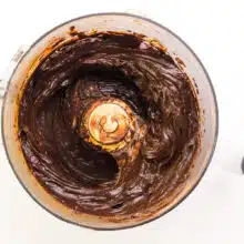 Looking down into a food processor with thick, chocolate mixture in it.