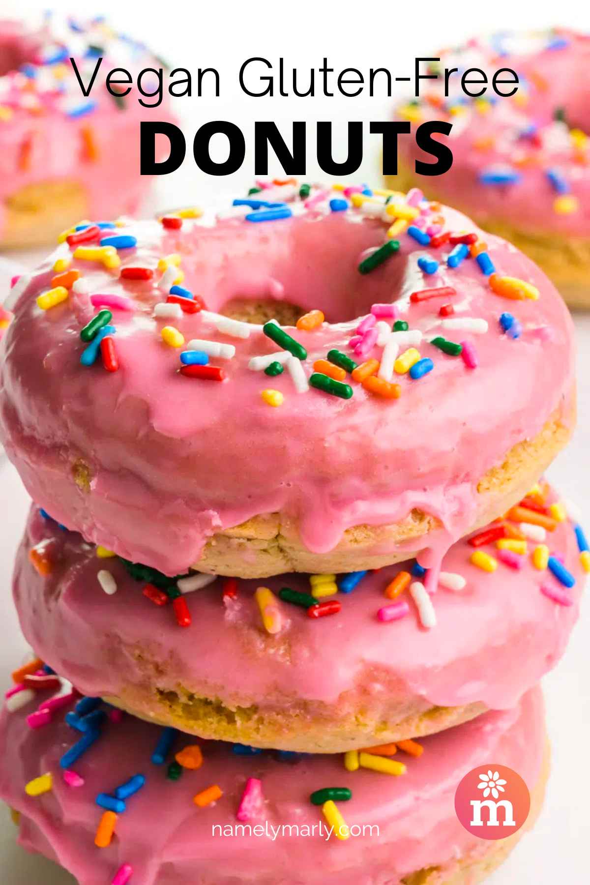 Donuts with pink glaze are stacked with more donuts behind the stack.  At the top it says, Vegan Gluten Free Donuts.
