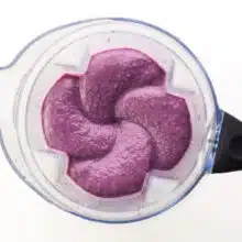 Looking down on purple smoothie mixture in a blender jar.