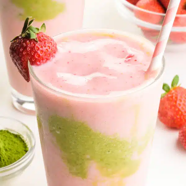 A closeup of a strawberry matcha smoothie in a glass.