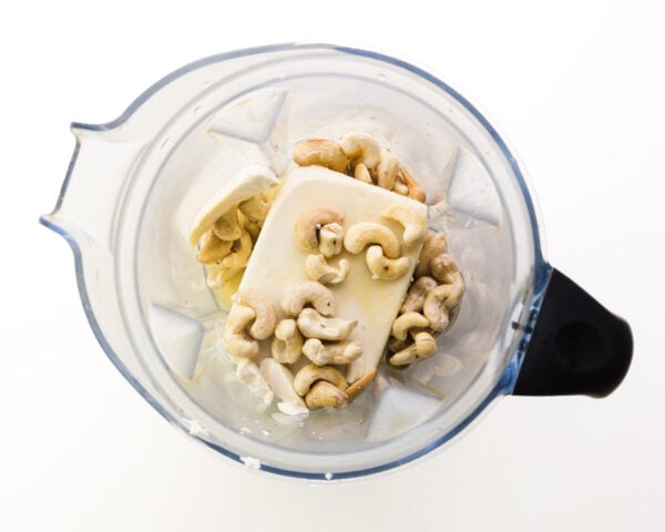Ingredients like tofu and cashews are in a blender jar, waiting to be blended.