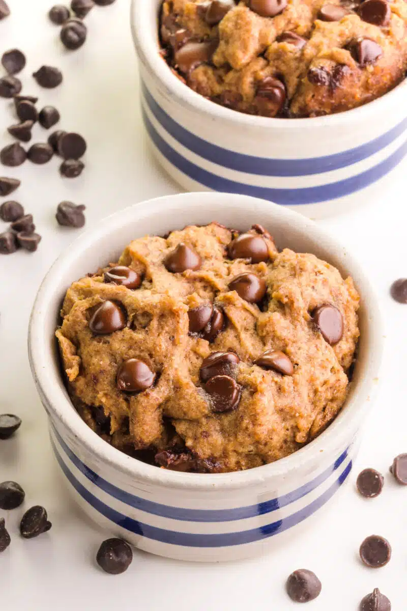 Looking down on microwave vegan cookies in bowls surrounded by chocolate chips.