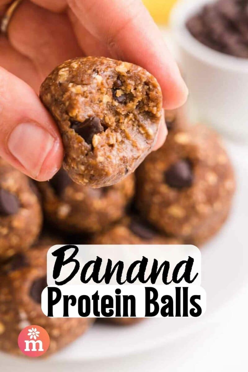 A hand holds a protein ball. The text reads, Banana Protein Balls.