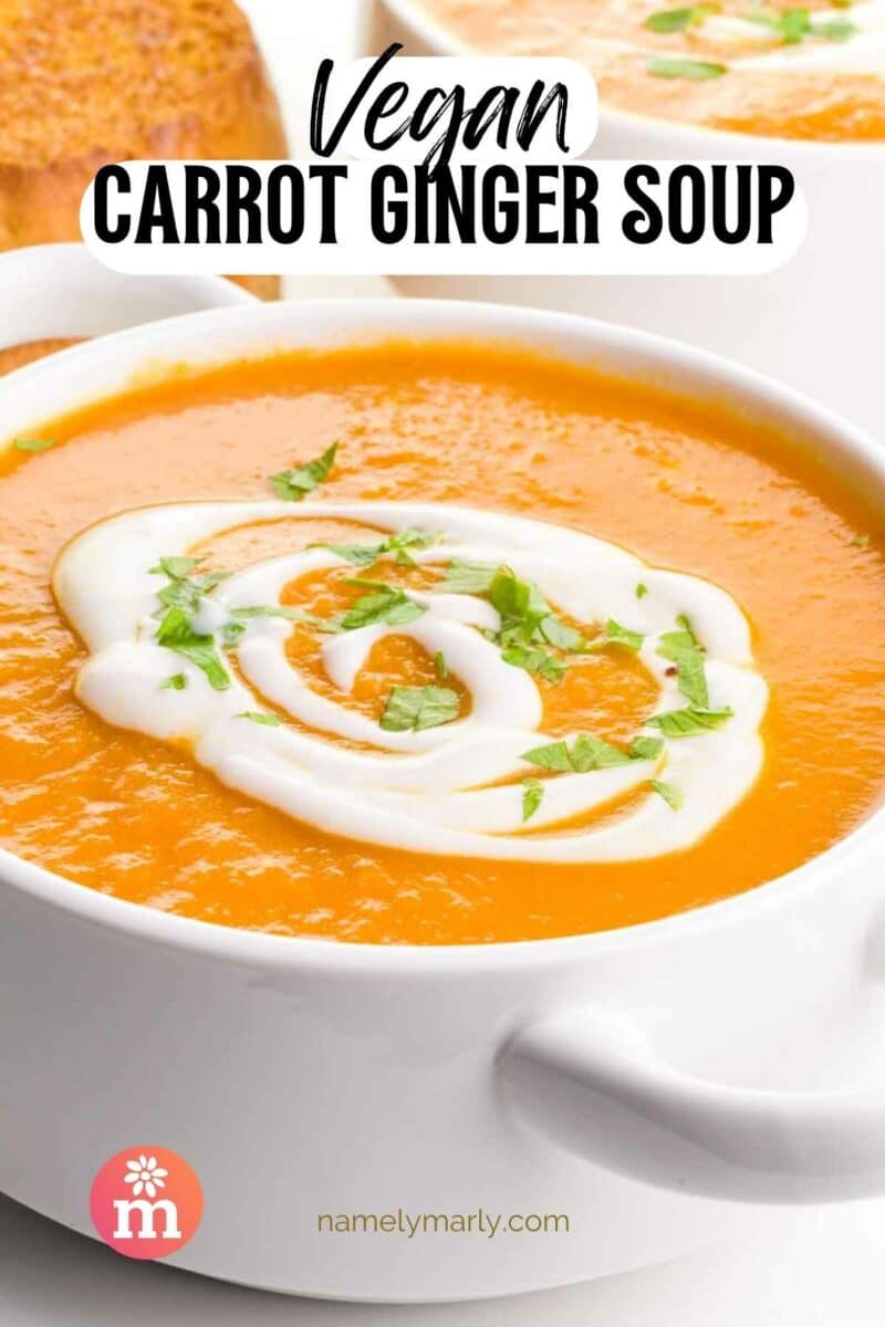A bowl of pureed carrot soup has sour cream swirls on top. The text reads, Vegan Carrot Ginger Soup.