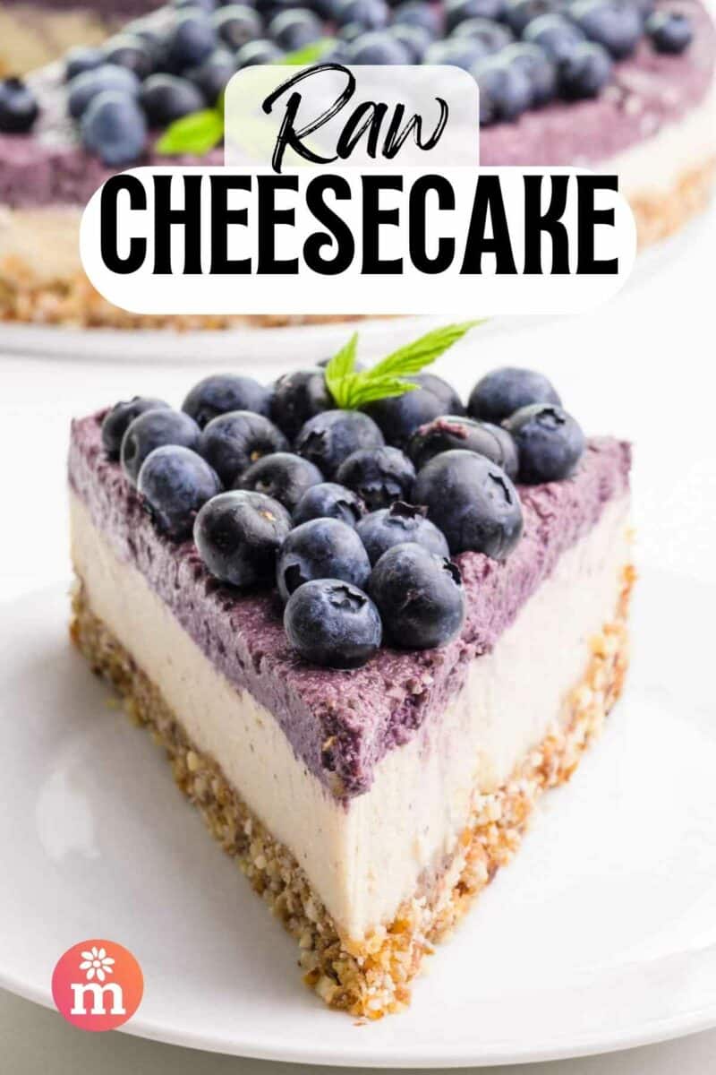 A slice of cheesecake has blueberry filling and fresh blueberries on top. The text reads Raw Cheesecake.