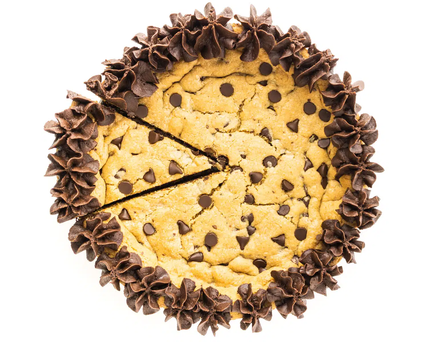 Looking down on a chocolate chip cookie cake with a slice cut out.