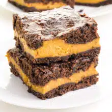 A stack of vegan pumpkin brownies sits on a white plate.