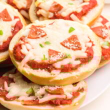 A closeup of vegan pizza bagel bites on a plate.