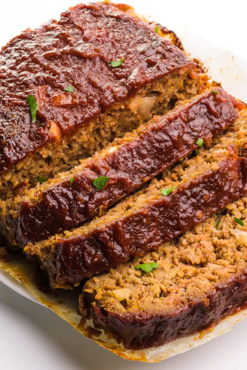 Looking down on an Impossible burger meatloaf with a few slices cut out and resting near the rest of the meatloaf.