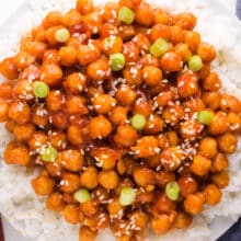 Looking down on a bowl of sticky chickpeas served over rice.