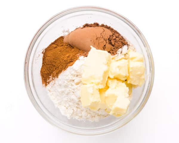 Streusel ingredients, such as cocoa powder, brown sugar, flour, and butter, are in a bowl.