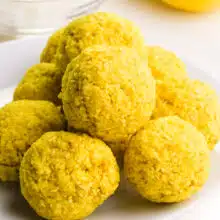 A stack of lemon energy balls are on a plate.
