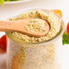 A wooden spoon rests in a jar of dairy-free ranch seasoning.