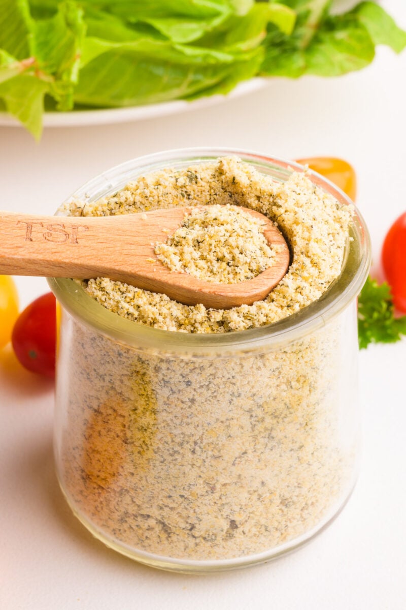 A wooden spoon rests in a bowl of ranch seasoning.