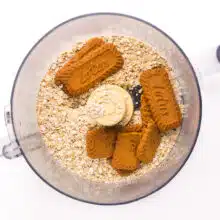 Looking down on a food processor bowl with oats and Biscoff cookies.