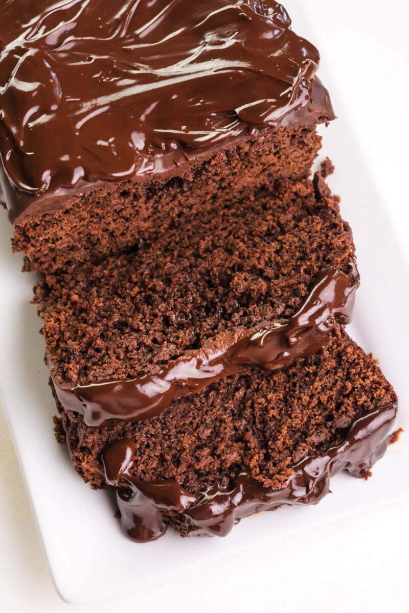 Looking down on a loaf of chocolate bread with a few slices in front of it.