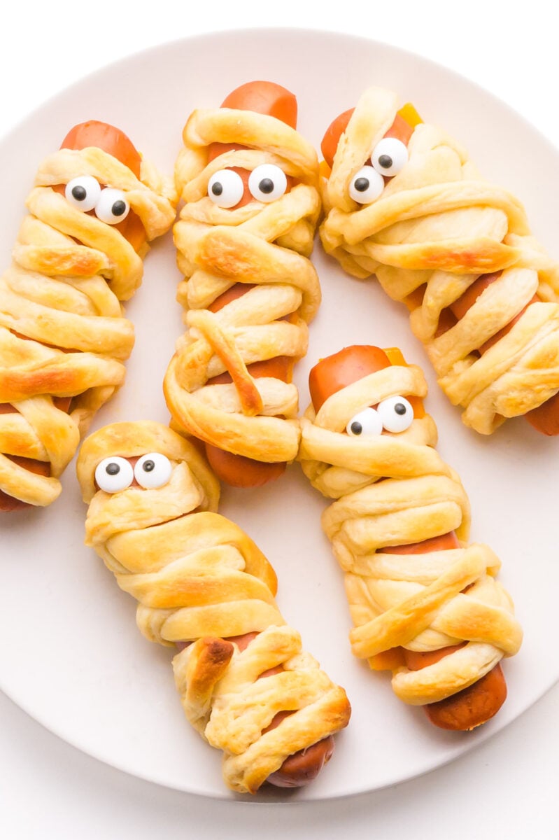 Looking down on a plate of vegan mummy dogs on a plate.