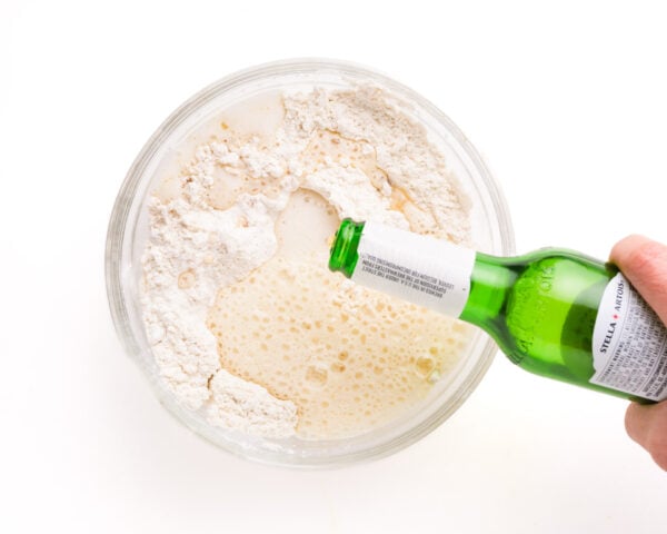 Beer is being poured into a bowl with flour ingredients.
