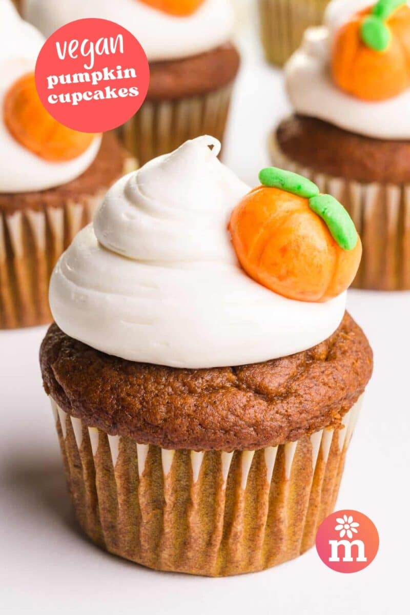 A closeup of pumpkin cupcakes on a white table. The text reads, Vegan Pumpkin Cupcakes.