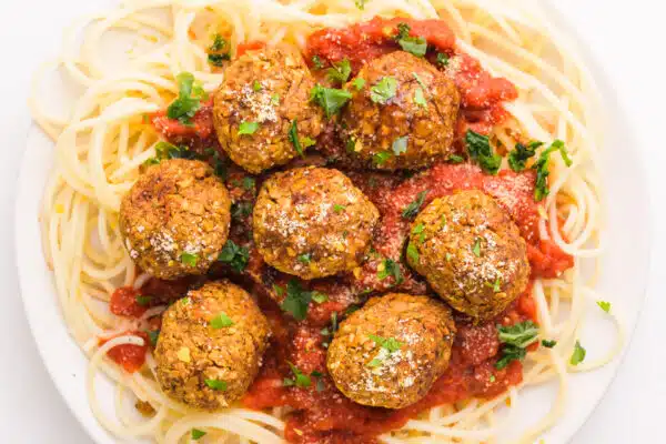 Looking down on a plate of pasta with chickpea meatballs and marinara sauce.