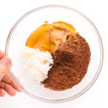Coconut oil, coco powder, peanut butter and other ingredients are in a mixing bowl.