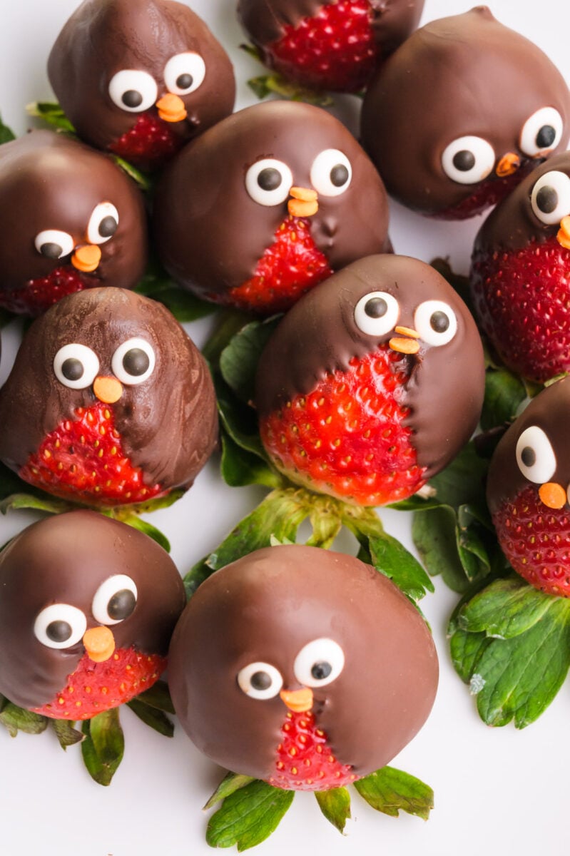 Looking down on several chocolate strawberry penguins on a plate.