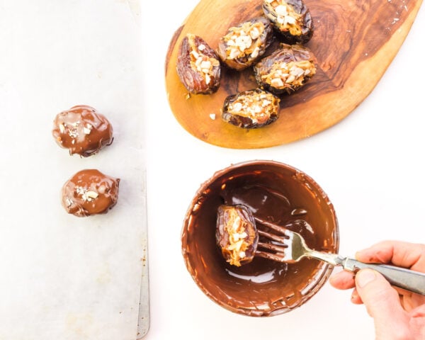Dates stuffed with peanut butter are being dipped in melted chocolate.