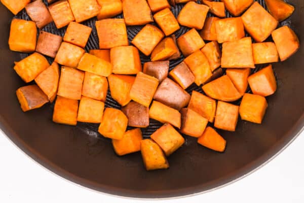 Looking down on skillet fried sweet potatoes in a pan.