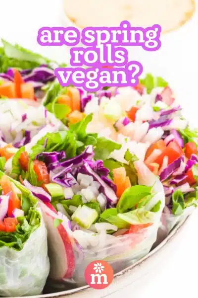A closeup of fresh veggie spring rolls has this text on top: Are spring rolls vegan?