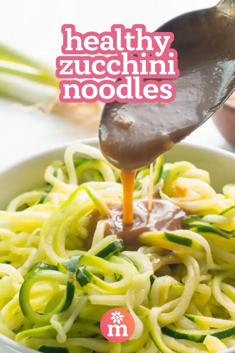 Sauce is being poured into a bowl with zoodles. The text reads, healthy zucchini noodles.
