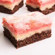 A closeup of a chocolate, vanilla, and strawberry Neapolitan Bar with more visible in the background.