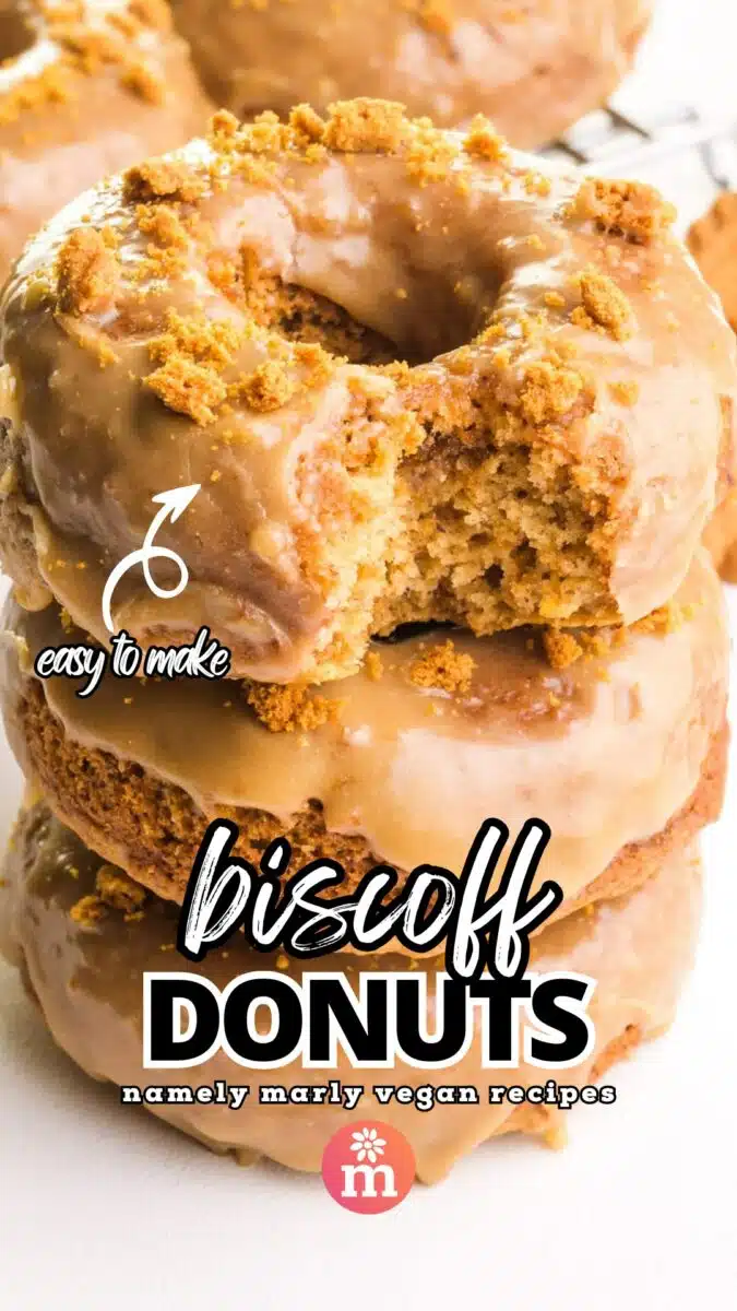 A stack of glazed donuts shows the top one with a bite taken out. An arrow points to the top donut with text that reads, easy to make! Then, more text reads, Biscoff Donuts, Namely Marly Vegan Recipes.