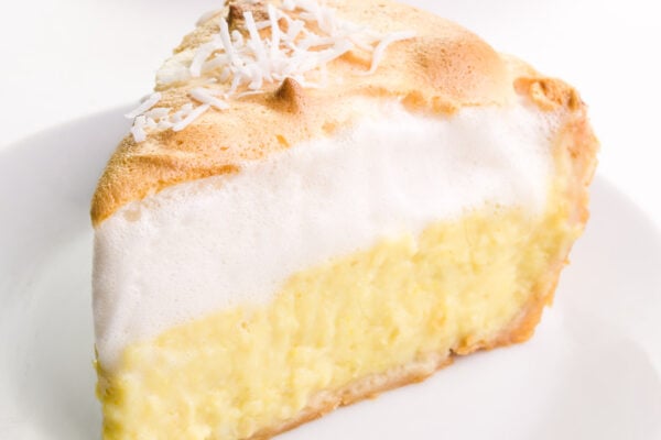A closeup of a slice of vegan coconut meringue pie on a plate.