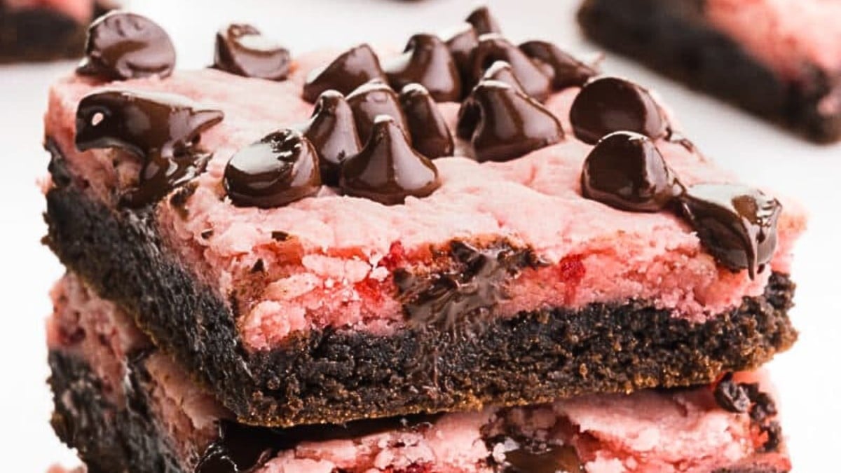 A closeup of a stack of chocolate strawberry bars with lots of chocolate chips on top.