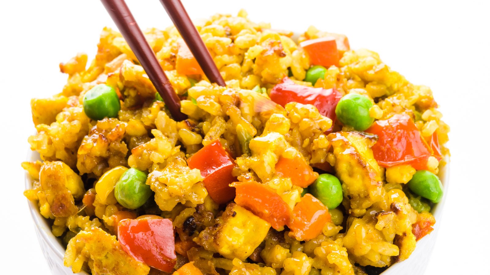 Chopsticks are dipping into a bowl of vegan fried rice.
