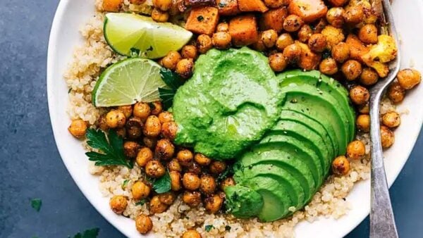 Looking down on a buddha bowl featuring rice topped with chickpeas and avocados.