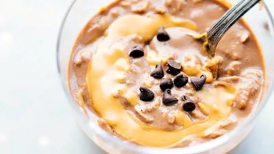Looking down on a jar of overnight oats with peanut butter swirls and chocolate chips on top.