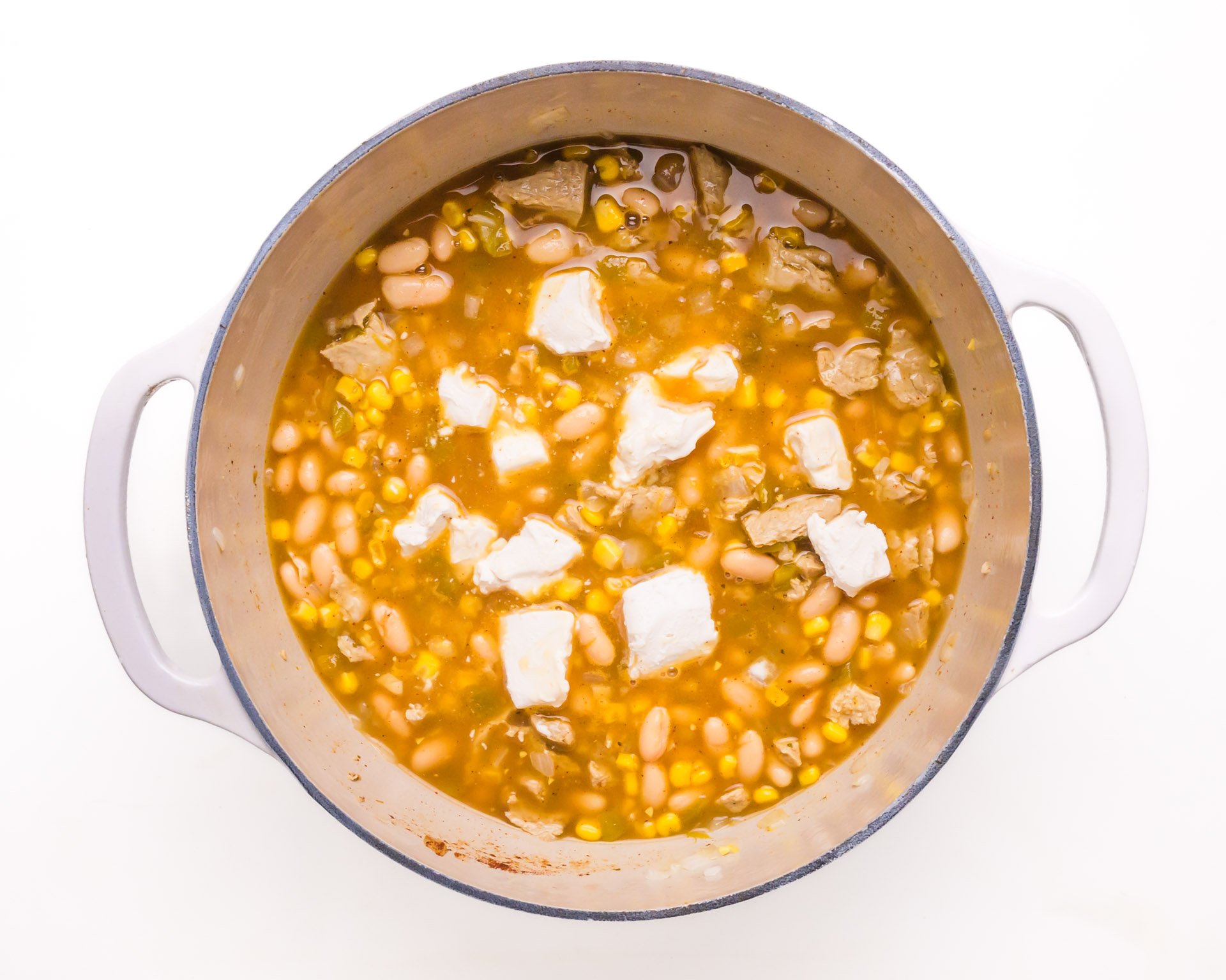 Cream cheese has been added to a pot of white bean chili.