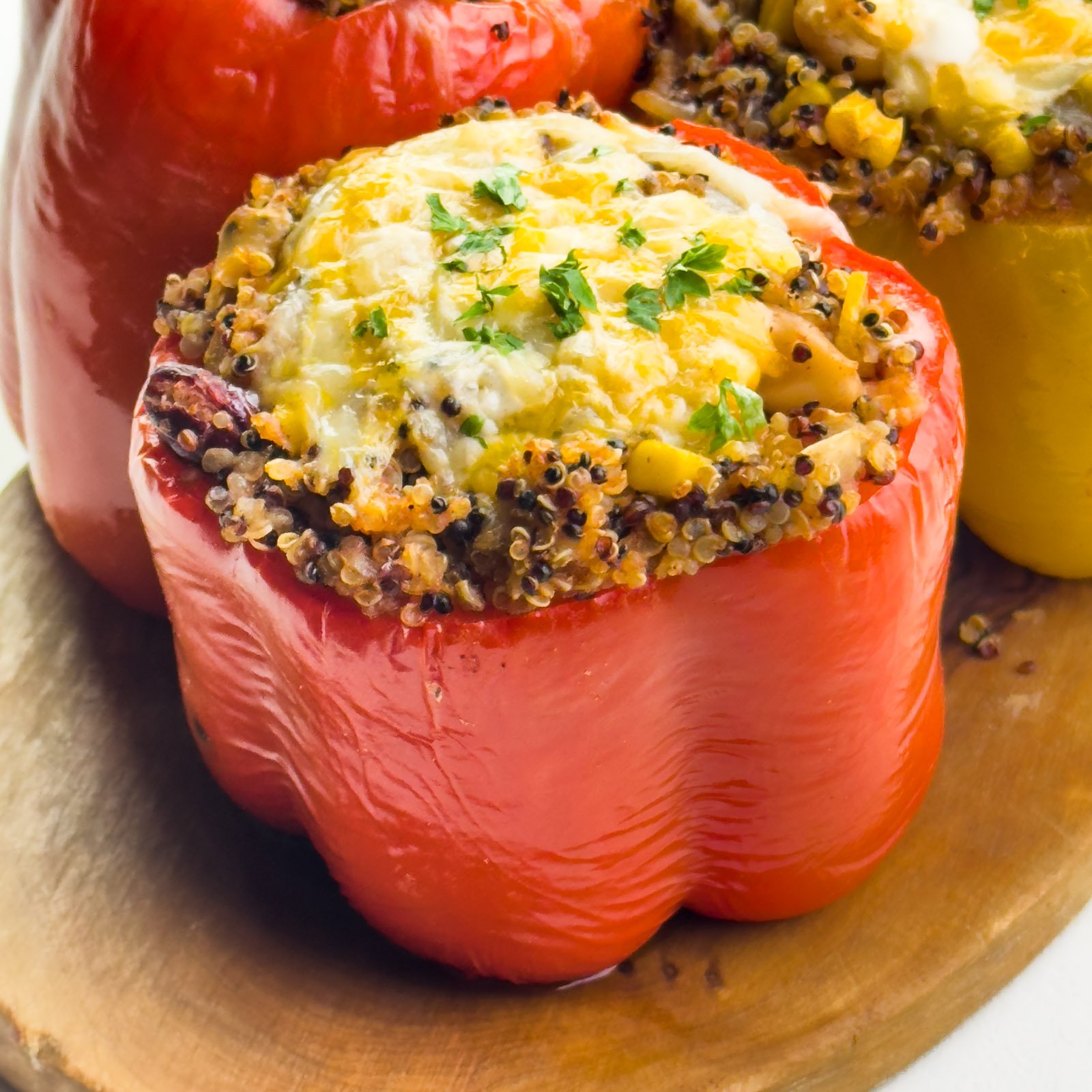 A roasted bell pepper is filled with quinoa and topped with melted cheese.