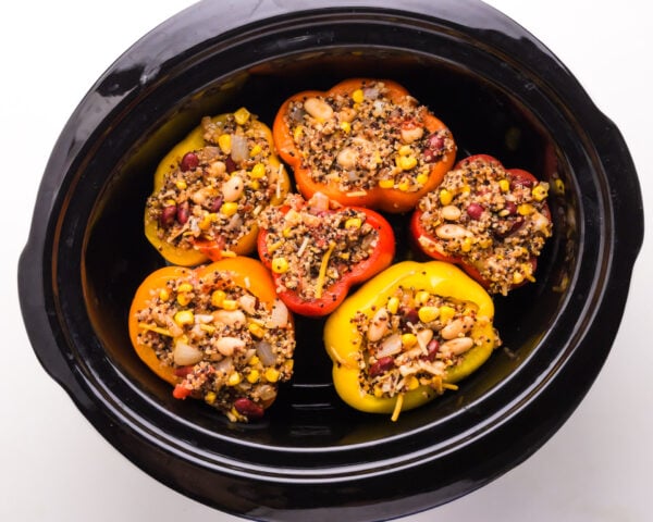Stuffed bell peppers are in a slow cooker.