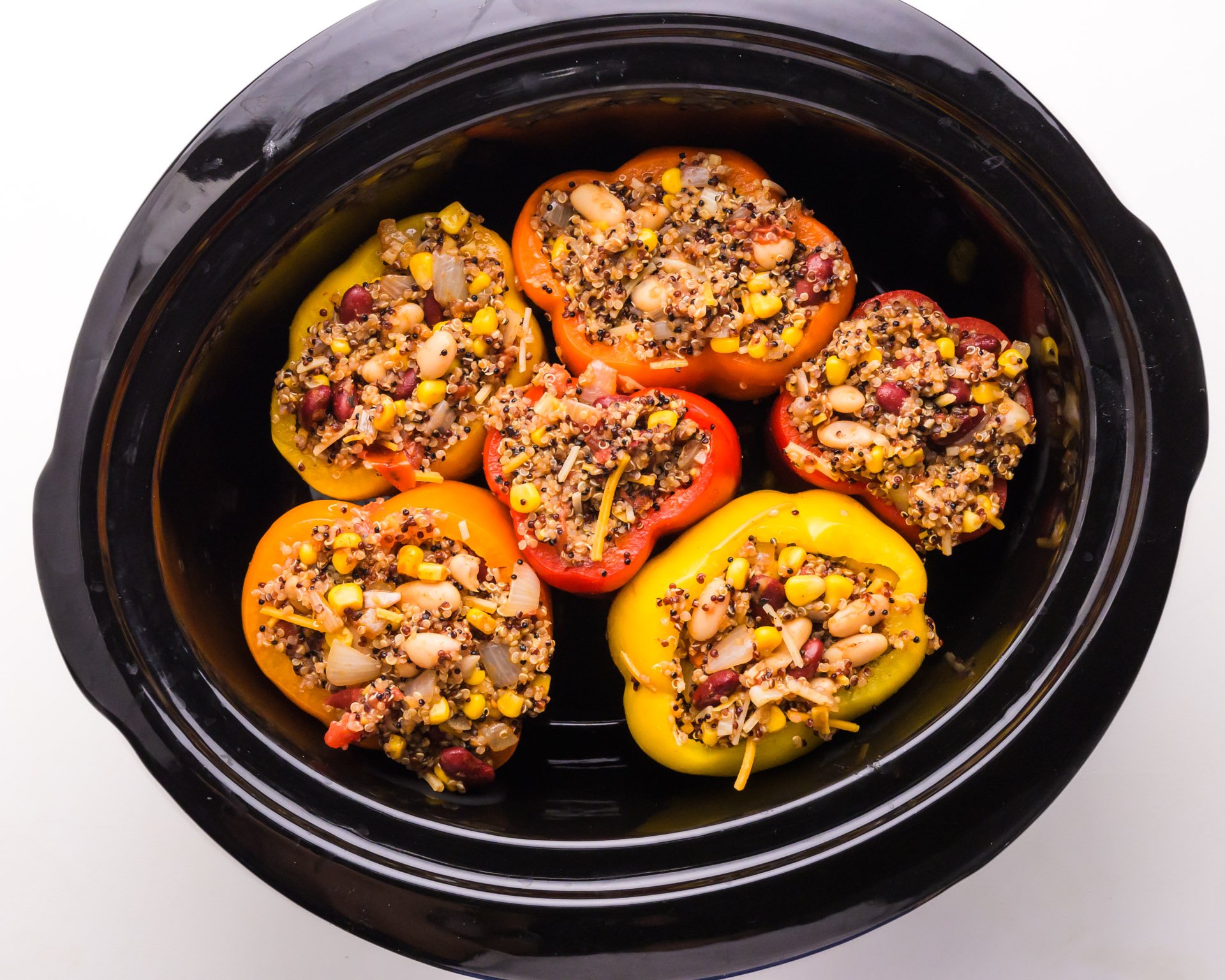 Stuffed bell peppers are in a slow cooker.