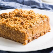 A Vegan Pumpkin Bar sits on a plate on a blue kitchen towel.