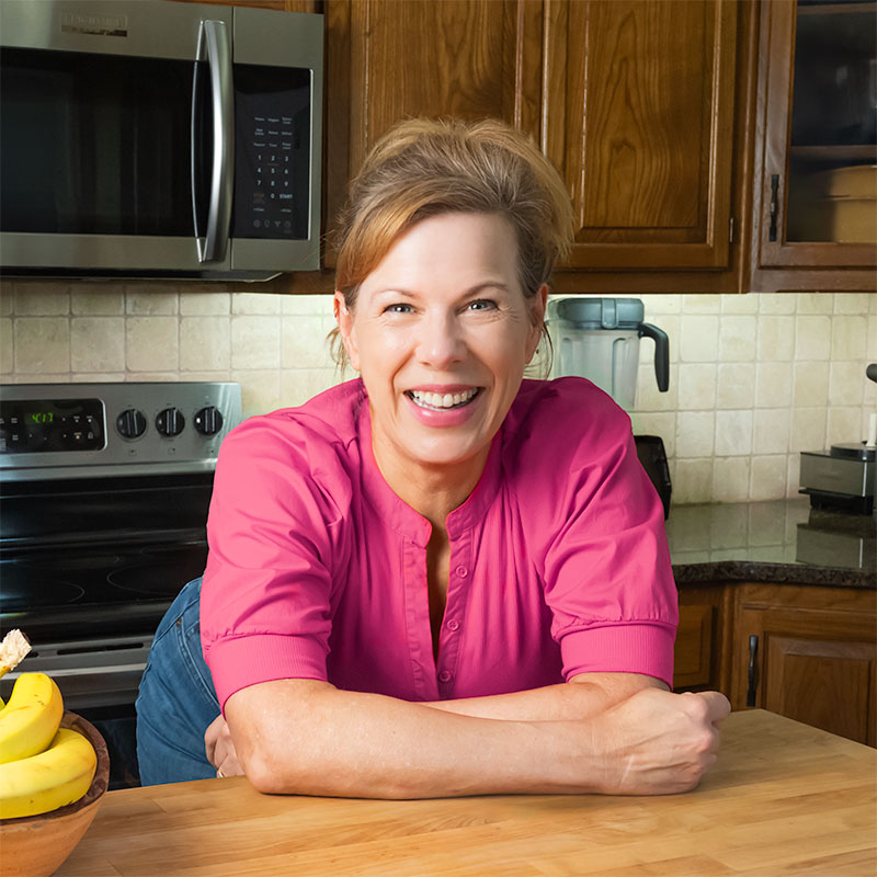 marly leaning over a butcher block surface in her kitchen
