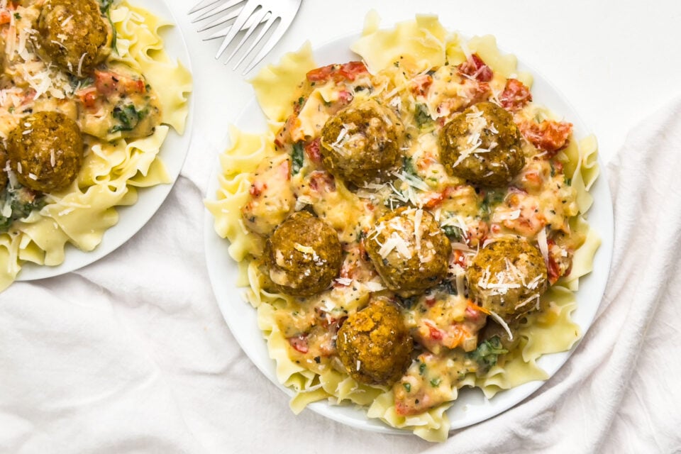 Looking down on a plate with pasta and vegan meatballs on top.